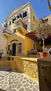 a large yellow building with a tree in front of it at Archontiko Hotel in Kalymnos