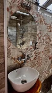 a bathroom with a sink and a mirror at Megruli House in Poti