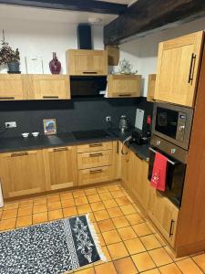 eine Küche mit Holzschränken und schwarzen Arbeitsplatten in der Unterkunft Le petit nid de cigogne in Colmar