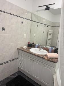 ein Badezimmer mit Waschbecken und Spiegel in der Unterkunft Le petit nid de cigogne in Colmar + 42 Fotos