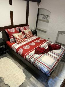 ein Bett mit roten und weißen Decken und Kissen in der Unterkunft Le petit nid de cigogne in Colmar