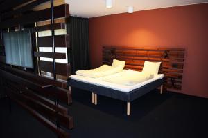 a bedroom with a bed and a wooden wall at Åsele Wärdshus in Åsele