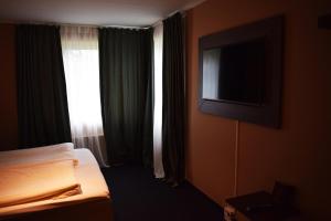 a hotel room with a bed and a flat screen tv at Åsele Wärdshus in Åsele