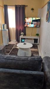 a living room with a couch and a table at Unique Place Thika 1 Bedroom in Thika