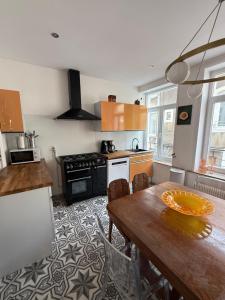 eine Küche mit Holztisch und ein Esszimmer in der Unterkunft Chambre Le Phare - Villa Les Embruns - à 5min à pied de Nausicaa, plage, centre Ville - Côte d'Opale in Boulogne-sur-Mer + 38 Fotos