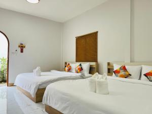 チェンカーンにあるสวนปาล์มการ์เด้นโฮม เชียงคาน Suanpalm Garden Home Changkhanの白い壁の部屋にベッドが2つある