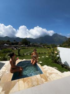two women sitting in a jacuzzi in a pool at Skyland Kintamani in Kubupenlokan