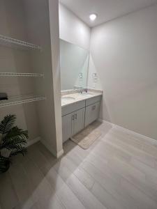 a bathroom with a sink and a mirror at Entire Brand New Modern Lake House Family Fun in Auburndale +33 photos
