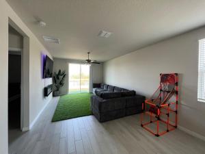 a living room with a black couch and a green rug at Entire Brand New Modern Lake House Family Fun in Auburndale