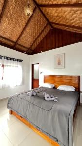 Green Corner Villa في بوكيت لاوانج: غرفة نوم بسرير كبير مع لوح رأس خشبي