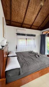 a large bed in a room with a window at Green Corner Villa in Bukit Lawang