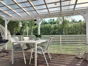 a white table and chairs under a pergola at Cozy detached house near the city in Rovaniemi