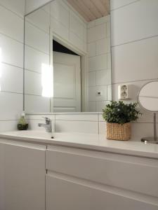 a white bathroom with a sink and a mirror at Cozy detached house near the city in Rovaniemi
