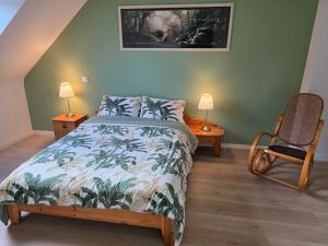 ein Schlafzimmer mit einem Bett, einem Stuhl und zwei Lampen in der Unterkunft les hirondelles in Péaule