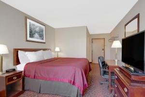 ein Hotelzimmer mit einem Bett und einem Flachbild-TV in der Unterkunft Express Inn Harrisburg South New Cumberland in New Cumberland