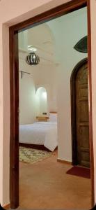 a bedroom with a bed and a mirror at Riad La Belle Vue in Boumalne