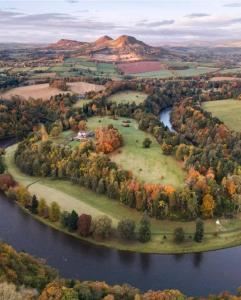 eine Insel inmitten eines Flusses mit Bäumen in der Unterkunft 1st Class 4 Bedroom 2 Bathrooms Sleeps 9 - 11 adults in Galashiels