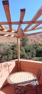 a table and chair on a balcony with a view at Riad La Belle Vue in Boumalne +7 photos