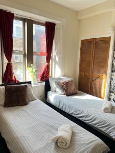 ein Schlafzimmer mit zwei Betten und einem Fenster in der Unterkunft 1st Class 4 Bedroom 2 Bathrooms Sleeps 9 - 11 adults in Galashiels