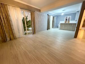 an empty living room with wooden floors and large windows at Nature Rock Guesthouse in Areni