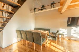 a dining room with a wooden table and chairs at HexenburgbeiDresden 4 Raum Architektengaleriewohnung mit Whirlwanne, Kamin, Balkon-Nähe Sächsische Schweiz Dresden in Großharthau