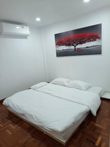 a bed in a room with a picture on the wall at A Day Home in Chiang Mai