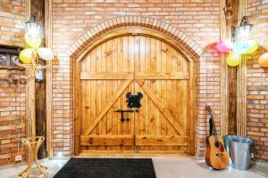 duże drewniane drzwi z gitarą w ceglanej ścianie w obiekcie Agroturystyka Catranch w mieście Grębków +28 zdjęć