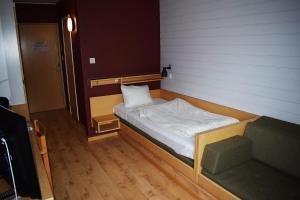 a small bed in a room with a wooden floor at Åsele Wärdshus in Åsele +19 photos