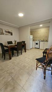 ein Esszimmer mit Tisch und Stühlen und eine Küche in der Unterkunft Edificio-Pellegrini PB in Bragado