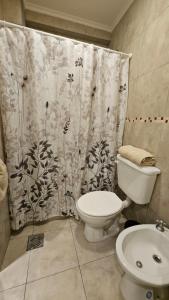 ein Badezimmer mit Toilette und Duschvorhang in der Unterkunft Edificio-Pellegrini PB in Bragado + 8 Fotos