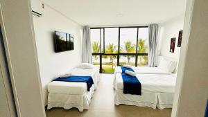 ein Schlafzimmer mit zwei Betten und einem großen Fenster in der Unterkunft MHV Milagres - Casa OKA 37 in Passo de Camarajibe + 101 Fotos