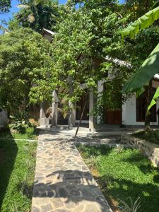 a walkway in front of a house with a tree at Rock Harmony Villa in Hikkaduwa