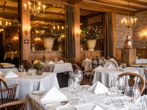 a restaurant with white tables and chairs and chandeliers at Hotel Bakker in Vorden