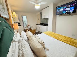 a bedroom with a bed and a tv on the wall at Refúgio Moderno Próx Metrô, 25 de Março and Expo Apt 24 in Sao Paulo