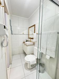 a white bathroom with a toilet and a sink at Refúgio Moderno Próx Metrô, 25 de Março and Expo Apt 24 in Sao Paulo