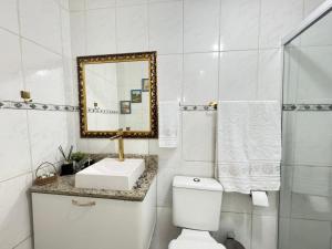 a white bathroom with a sink and a mirror at Refúgio Moderno Próx Metrô, 25 de Março and Expo Apt 24 in Sao Paulo +12 photos