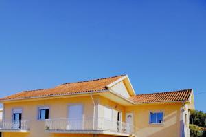 a yellow house with a balcony at Casa com jardim privado e estacionamento no interior in Amares