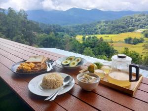 a table with plates of food on a table with a view at ดิ เอสเคป อินทนนท์ - The Escape Inthanon in Ban Yang
