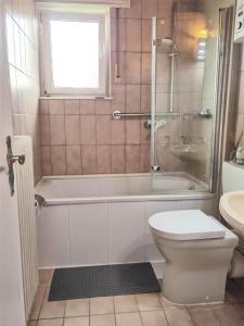 a bathroom with a tub and a toilet and a sink at Family-Friedndly Home with Large Garden &BBQ Grill in Dreieich