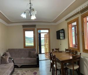 a living room with a table and a couch at Duha Uzungöl Apart Otel in Çaykara