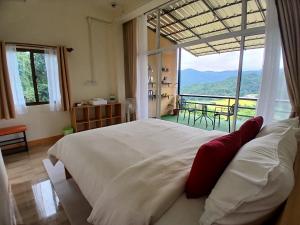 a bedroom with a large bed and a large window at ดิ เอสเคป อินทนนท์ - The Escape Inthanon in Ban Yang
