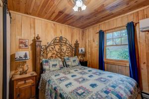 a bedroom with a bed in a room with wooden walls at Bridgepoint Cabin in Banner Elk
