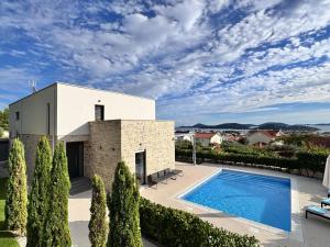 a villa with a swimming pool and a building at Villa Puro in Tribunj