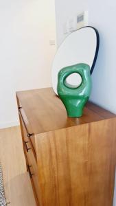 een groene vaas bovenop een houten kast bij serenity villa sharm alfujerah in Fujairah +29 foto's