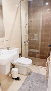 een badkamer met toilet en glazen douche bij serenity villa sharm alfujerah in Fujairah