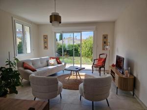 ニヨンにあるLes LUCIOLESのソファと椅子とテレビのあるリビングルーム