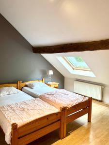 a bedroom with two beds and a skylight at Au petit Clocher - vakantiehuis Ardennen in Ferrières