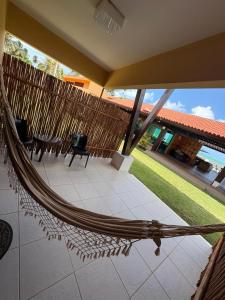 a hammock on a house with a view of a patio at Pousada Dra Lindalva in Maragogi