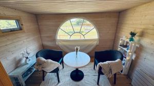 a room with a table and chairs and a window at Tiny House mit Pferdeblick in Travenhorst