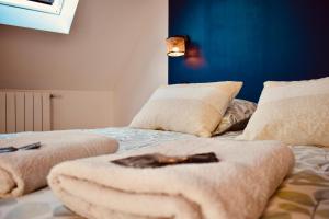 ein Schlafzimmer mit zwei Betten mit Handtüchern darauf in der Unterkunft L'AQUARELLE - Escapade normande pour 6 pers in Grugny